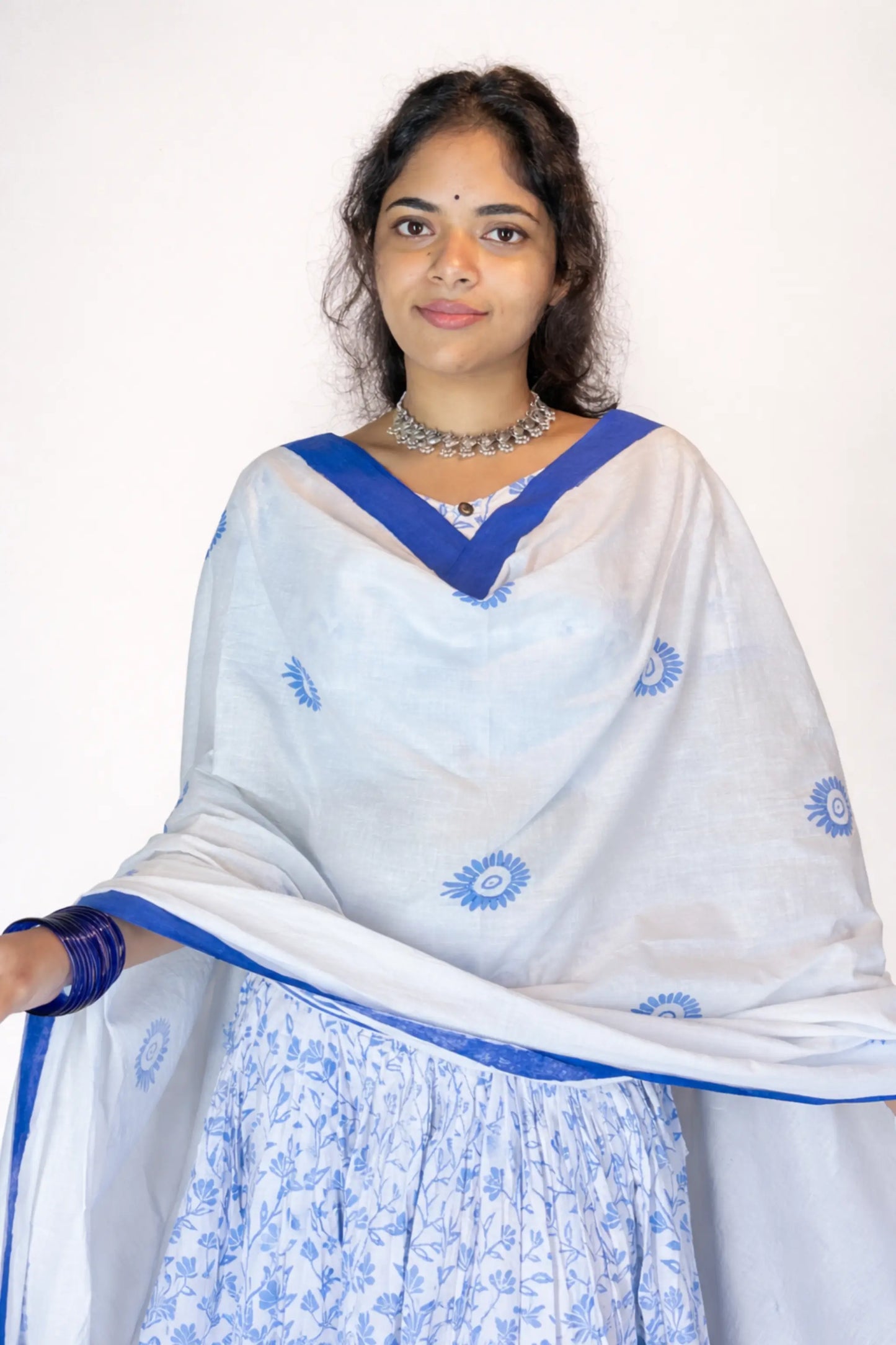 Upper body close-up of a model wearing a blue and white block print Charubala cotton gopi dress