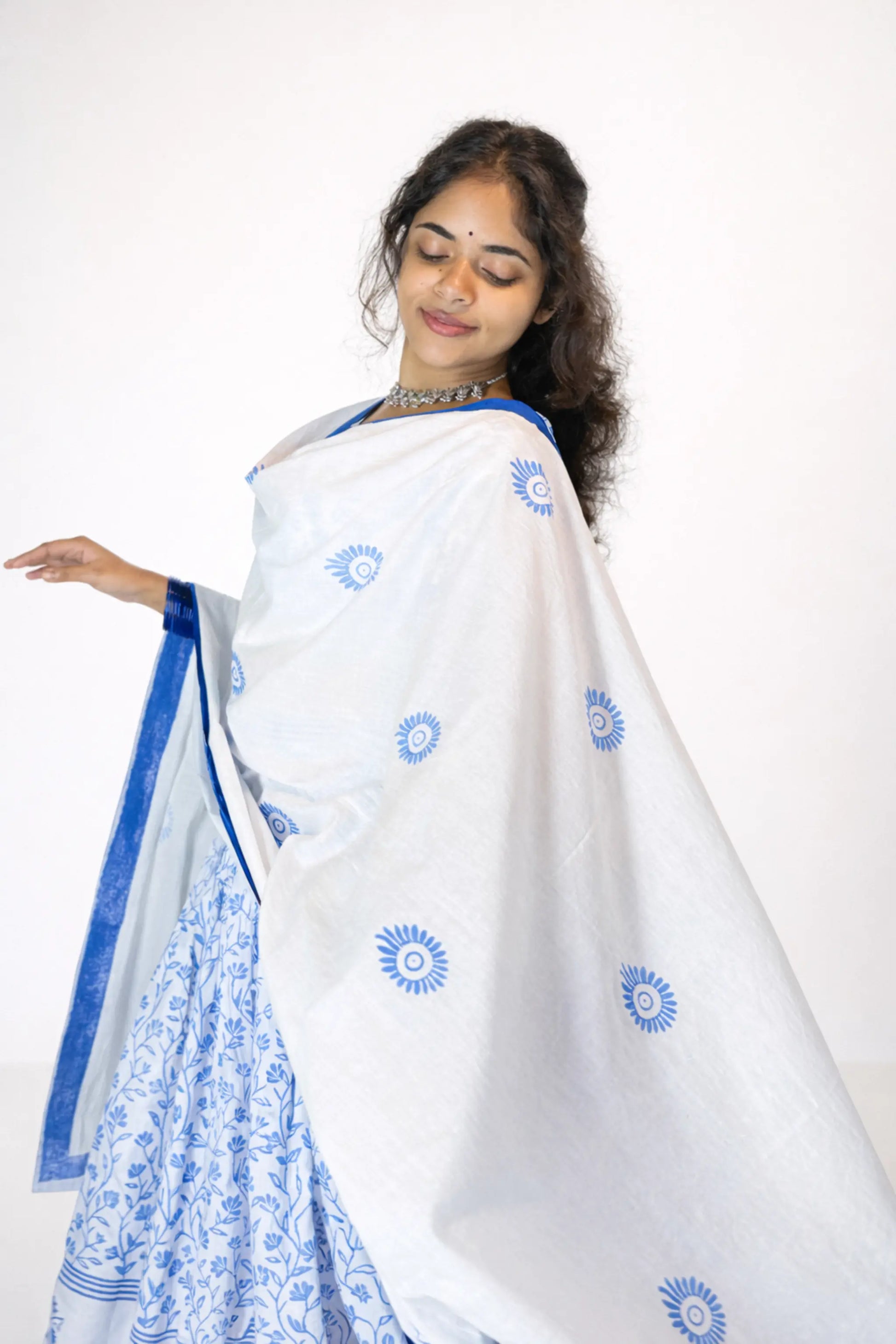 Front view of a model wearing a blue and white block print Charubala cotton gopi dress in studio background