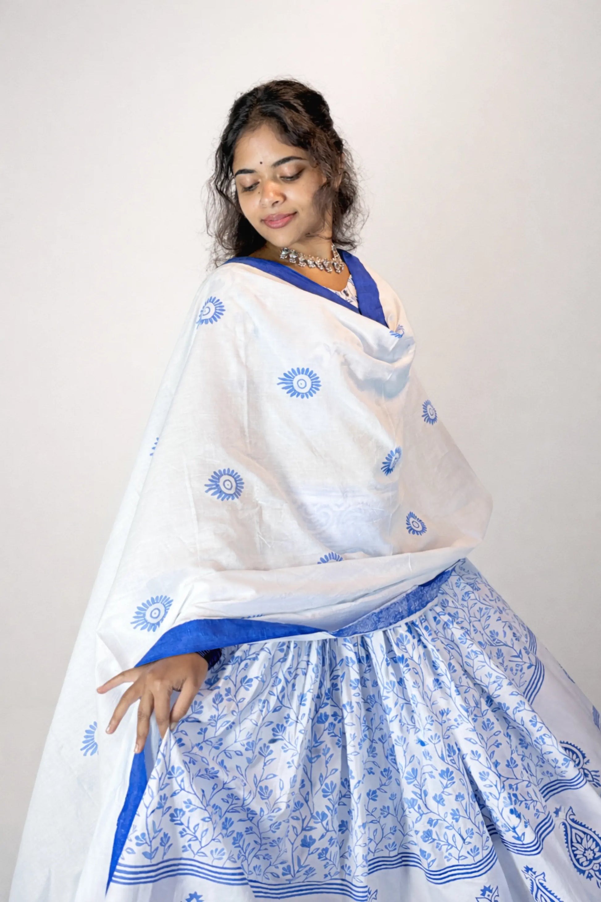 Close view of the transparent dupatta and flared skirt of a blue and white Charubala cotton gopi dress