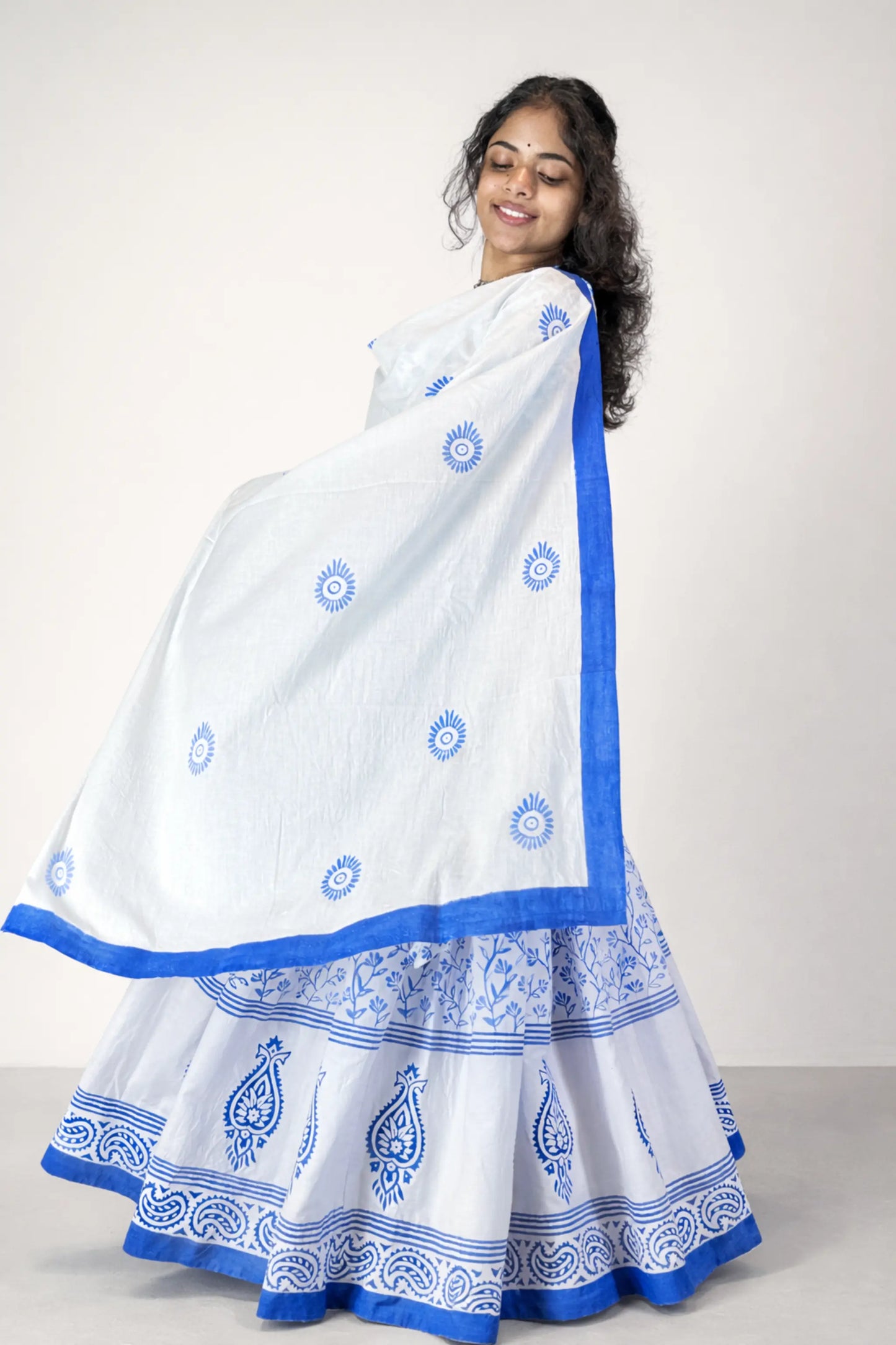 Side angle view of a blue and white block print Charubala cotton gopi dress with flared skirt and lightweight dupatta