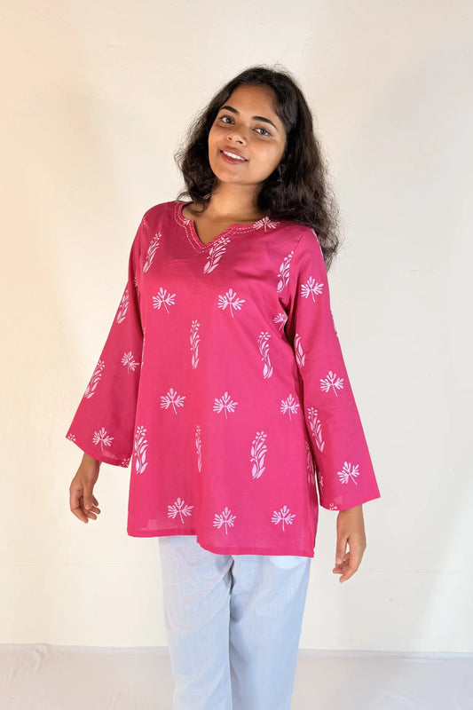 Woman wearing a pink floral top against a white background