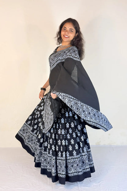 Woman wearing a colorful traditional outfit with a black blouse, black saree, and black sari.