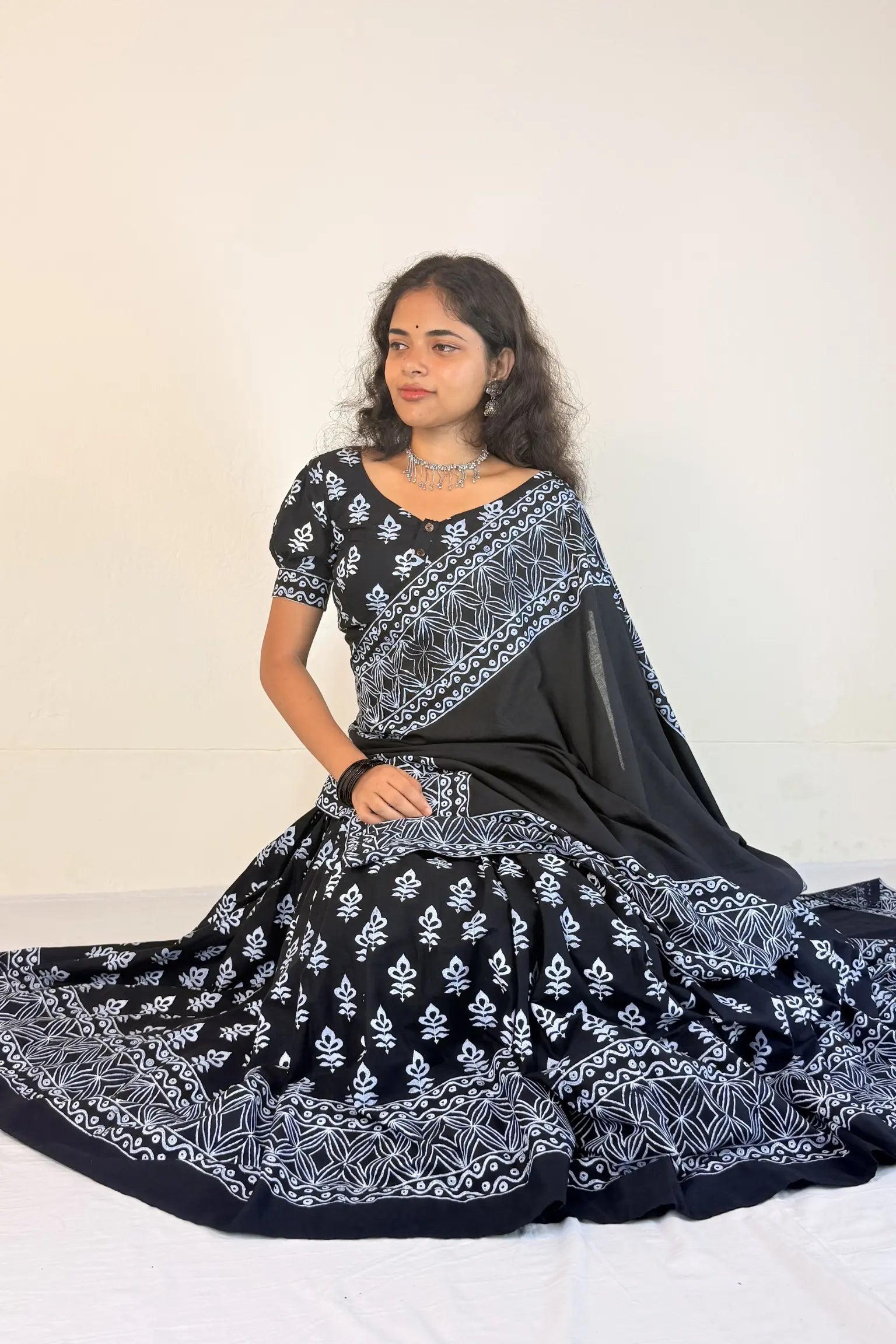 Woman wearing a black and white patterned Gopi Skirt Set on a plain background