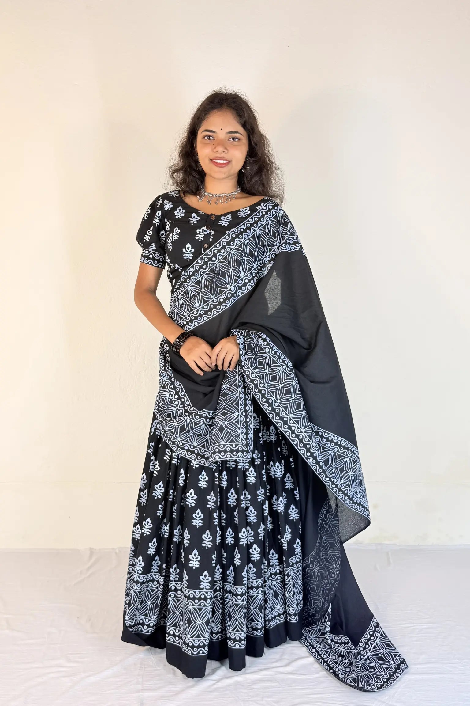 Woman wearing a black and white patterned Gopi Skirt Set against a white background