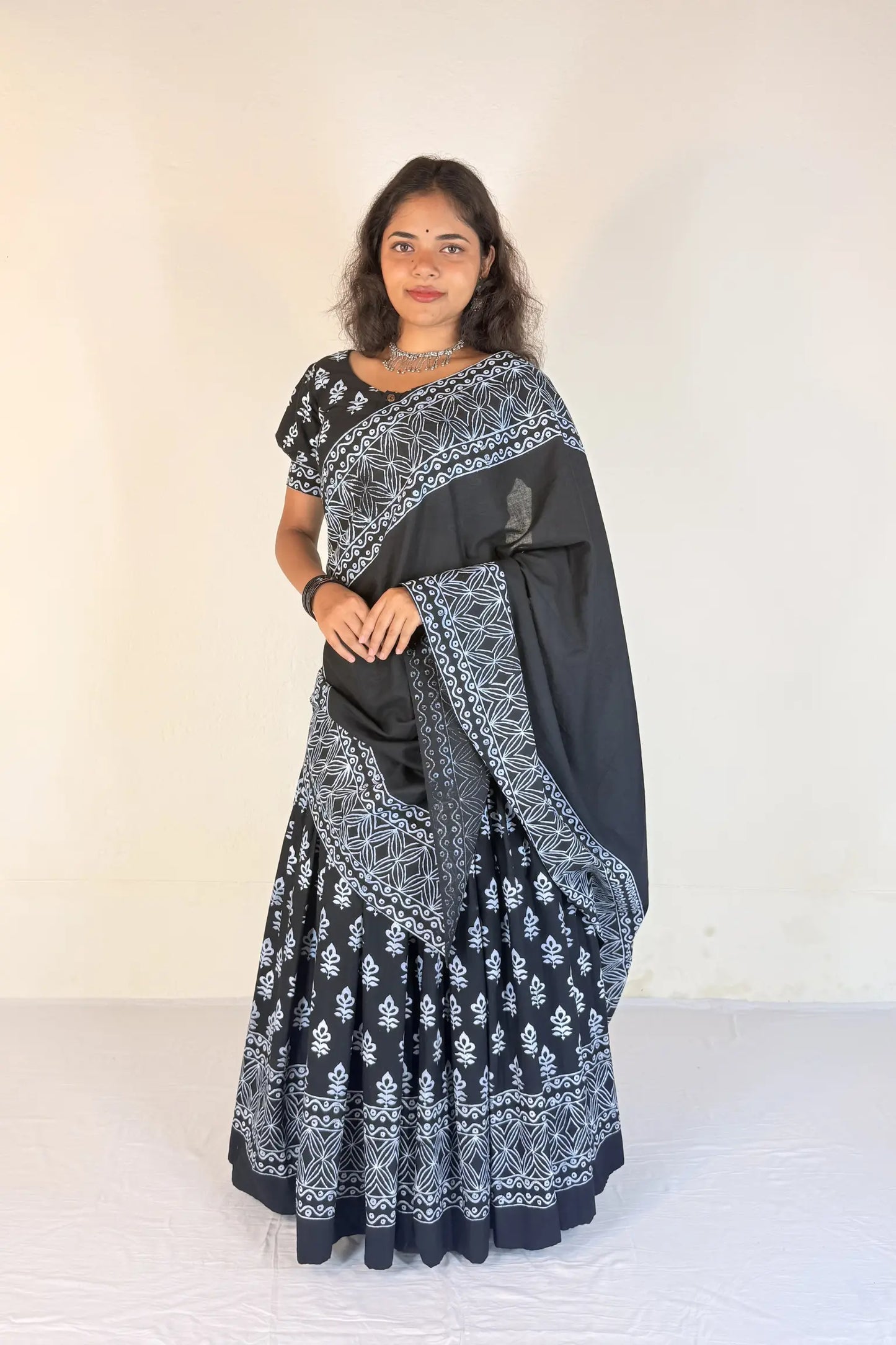Woman wearing a colorful Gopi Dress with a black and white design on a white background