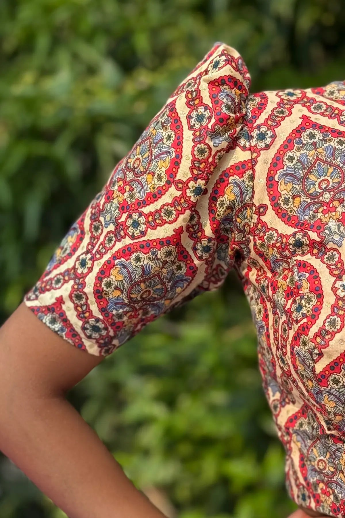 Detailed view of handcrafted cotton blouse sleeve with intricate paisley block print and fine stitching