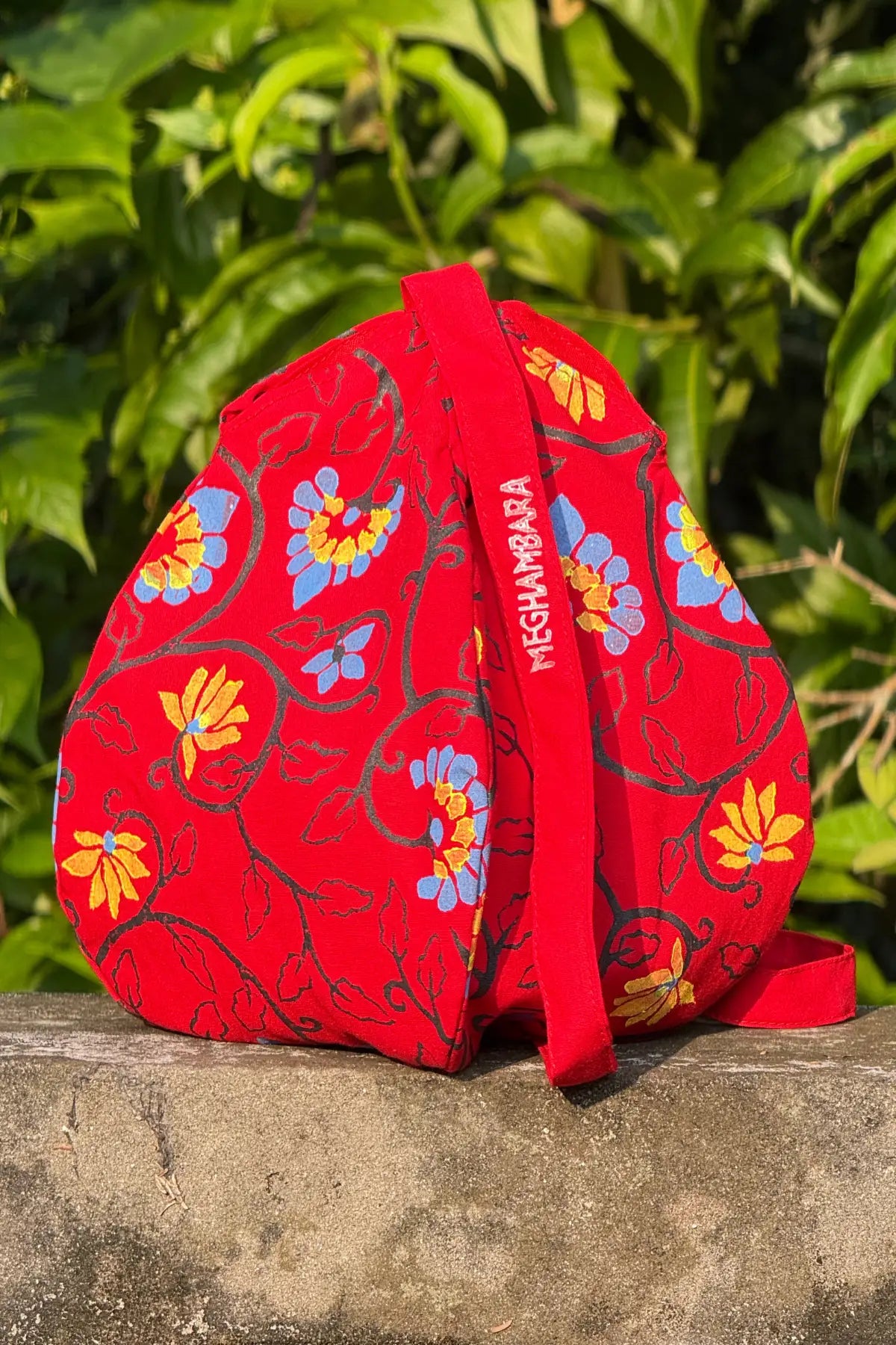 Red handcrafted cotton japa mala bag featuring floral block print design and structured shape, eco-friendly spiritual accessory