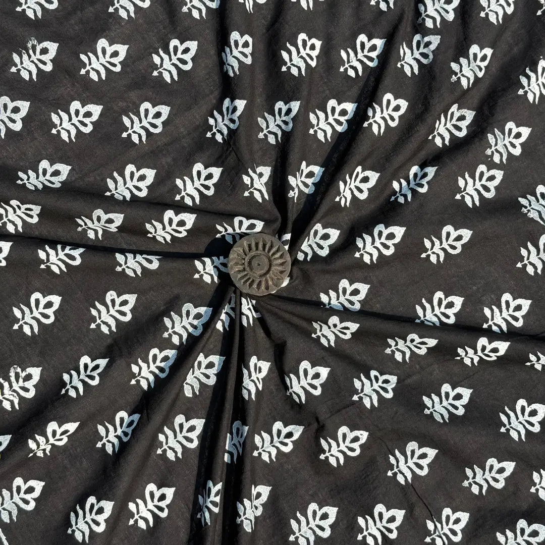 Black fabric with white floral pattern, tied in a knot.