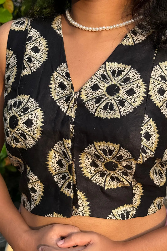 Front close-up of model wearing black handcrafted cotton blouse with intricate block print, sleeveless V-neck design
