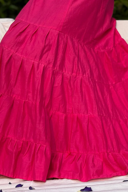 Close-up view of bright pink cotton petticoat fabric showing soft texture, natural wrinkles, and neat stitching details.