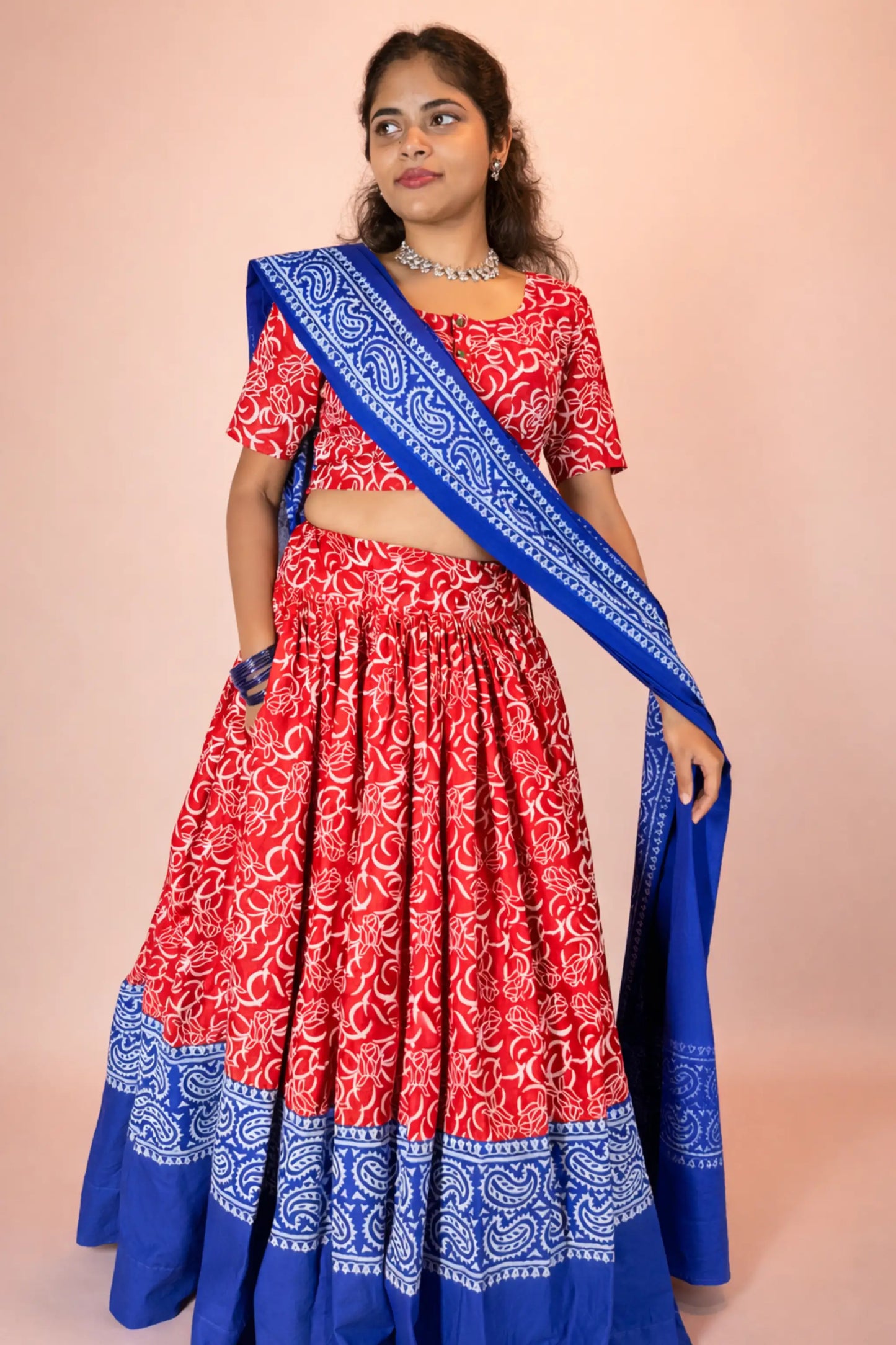 Elegant pose of Ranga Moti red and blue pure cotton gopi dress highlighting folk inspired hand block print