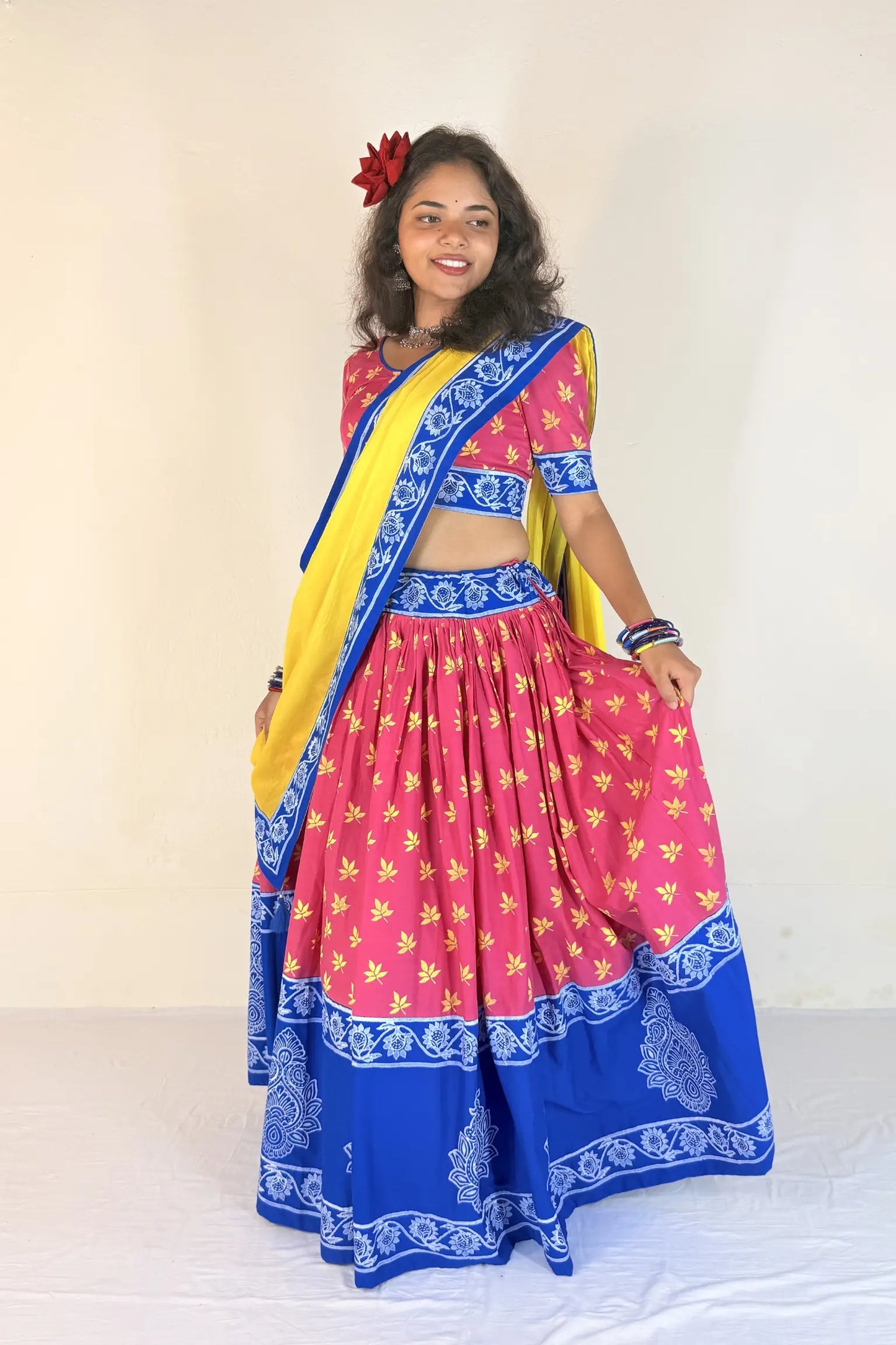 Woman wearing a blue and white traditional outfit with a matching dupatta against a plain background