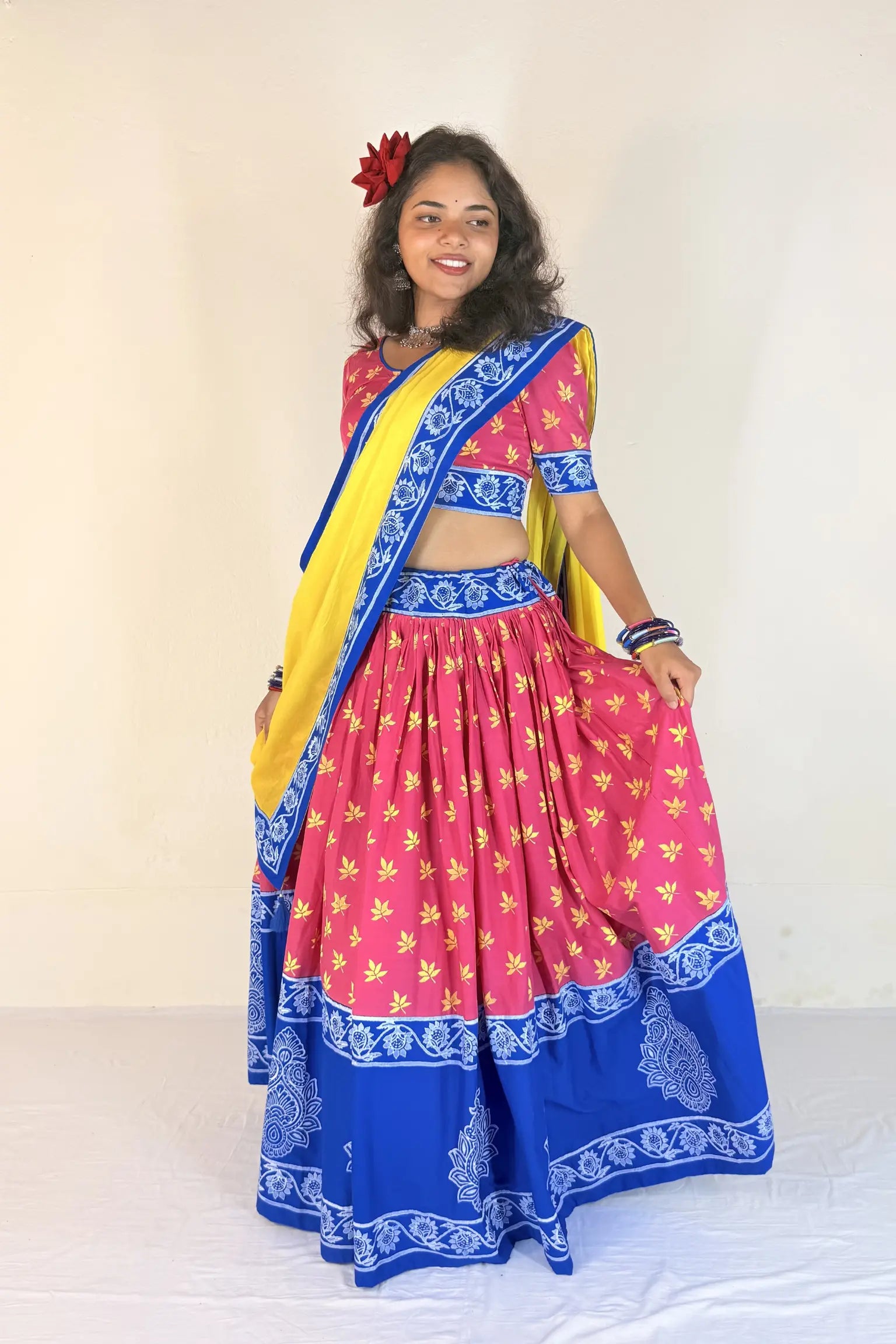 Woman wearing a blue and white traditional outfit with a matching dupatta against a plain background