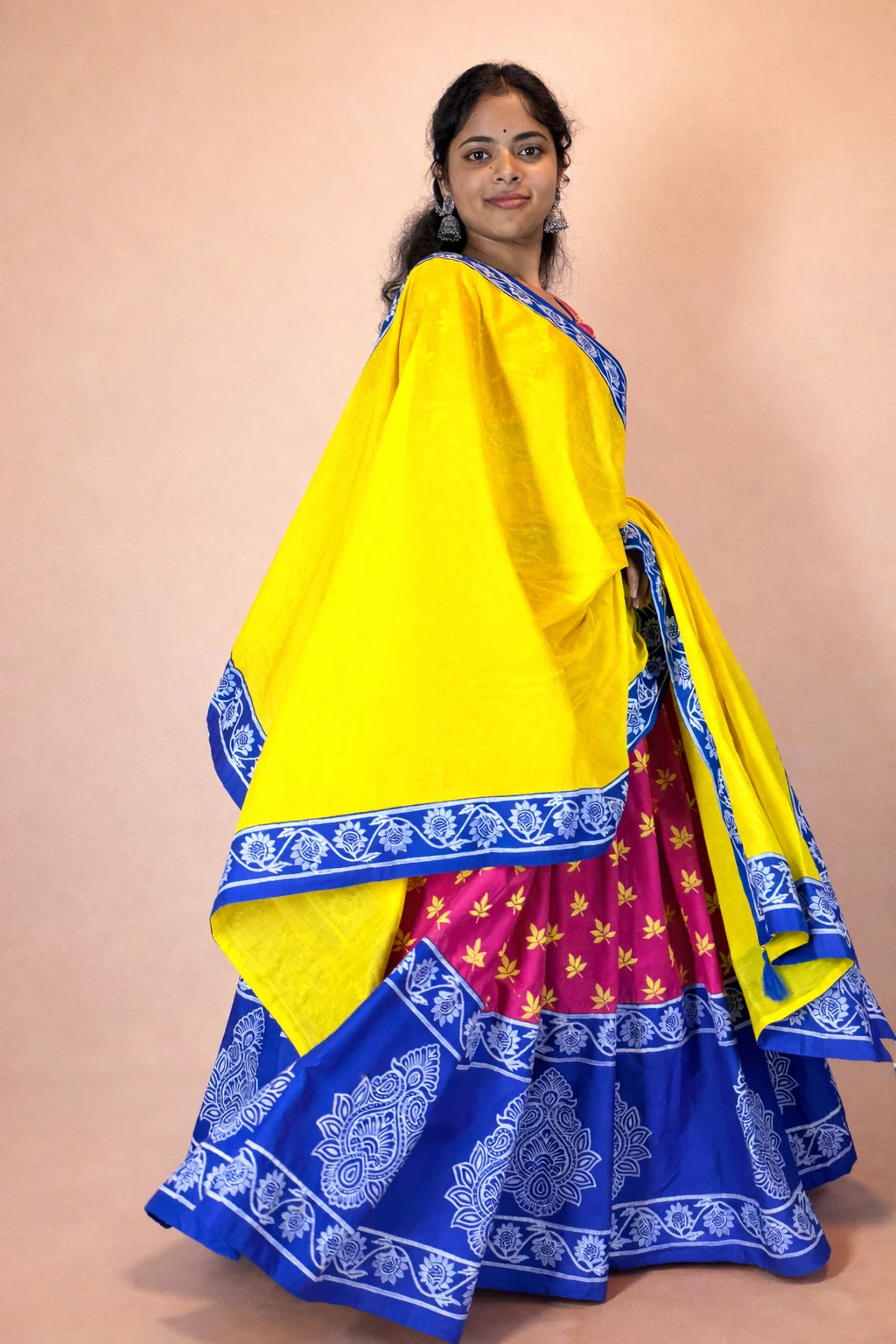 Model wearing Rasika Rangini Gopi dress made of pure cotton with hand block print, featuring yellow dupatta and blue border with full flared skirt