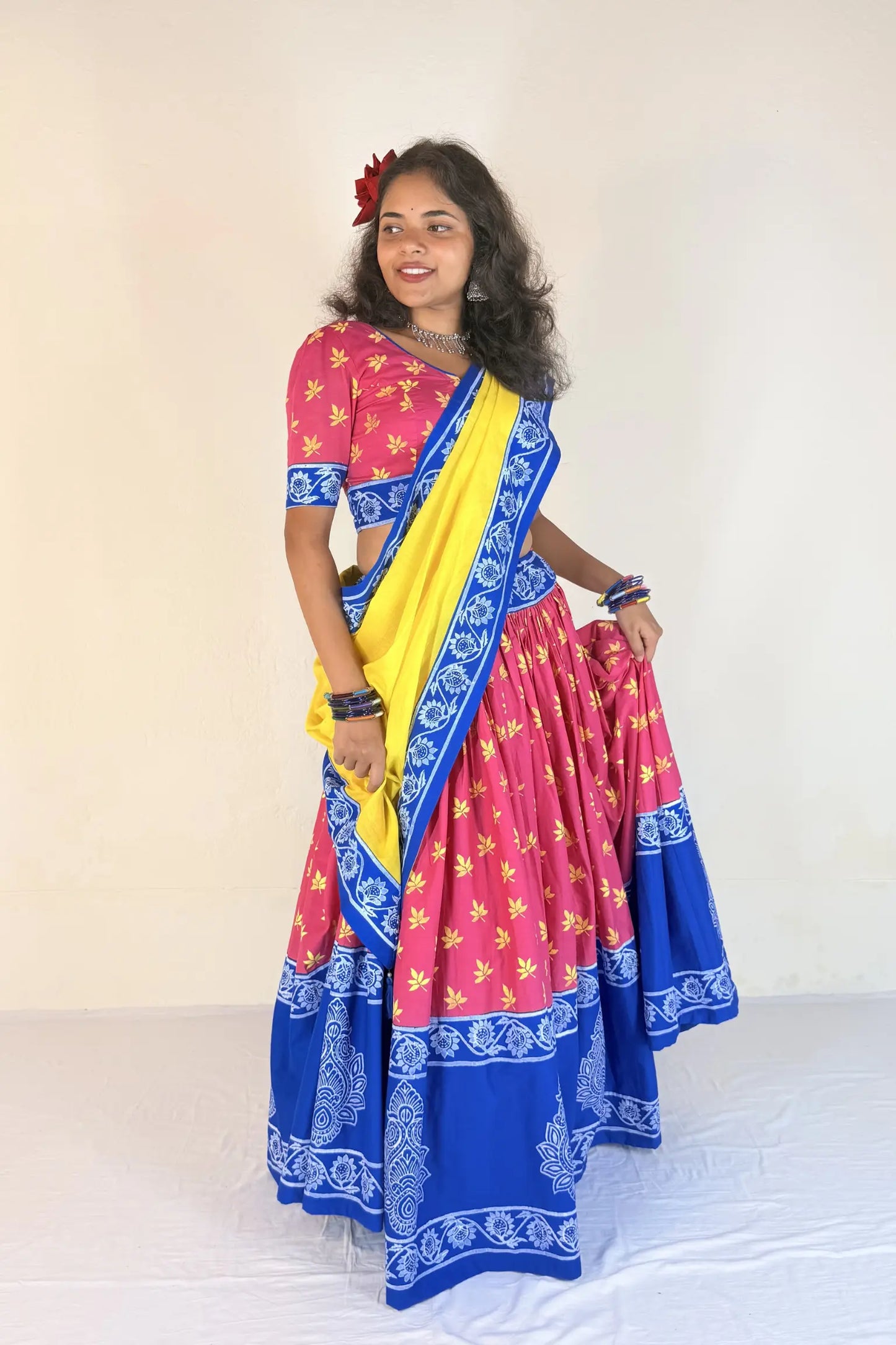 Woman wearing a white Gopi Dress with blue patterns against a plain background