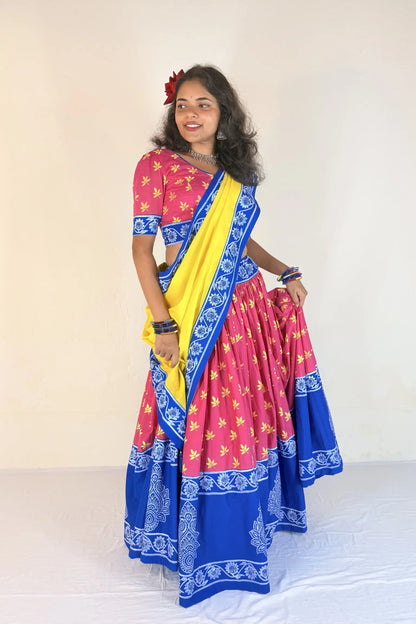 Woman wearing a white Gopi Dress with blue patterns against a plain background
