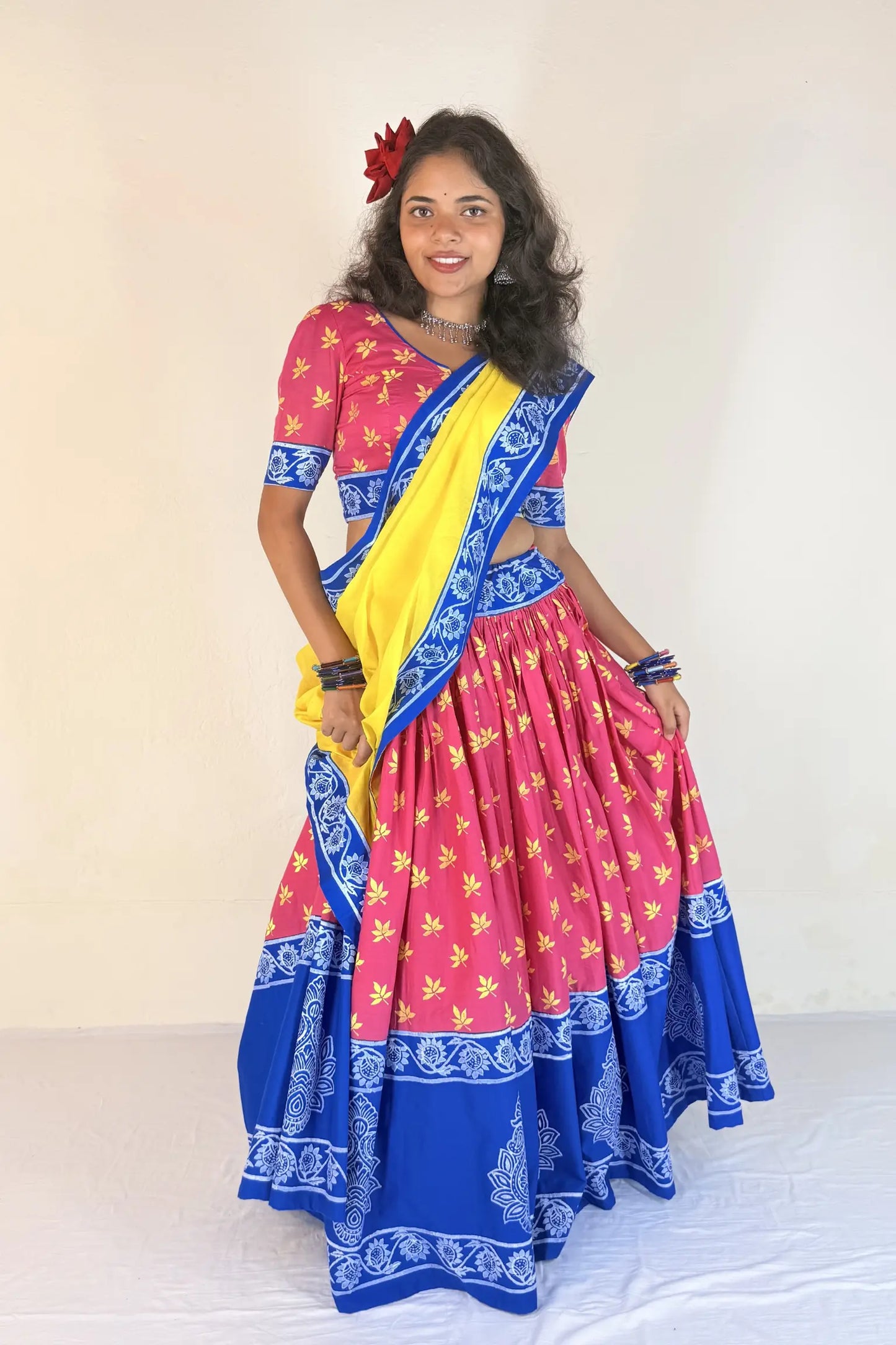 Woman wearing a colorful Gopi Dress with a yellow blouse against a white background