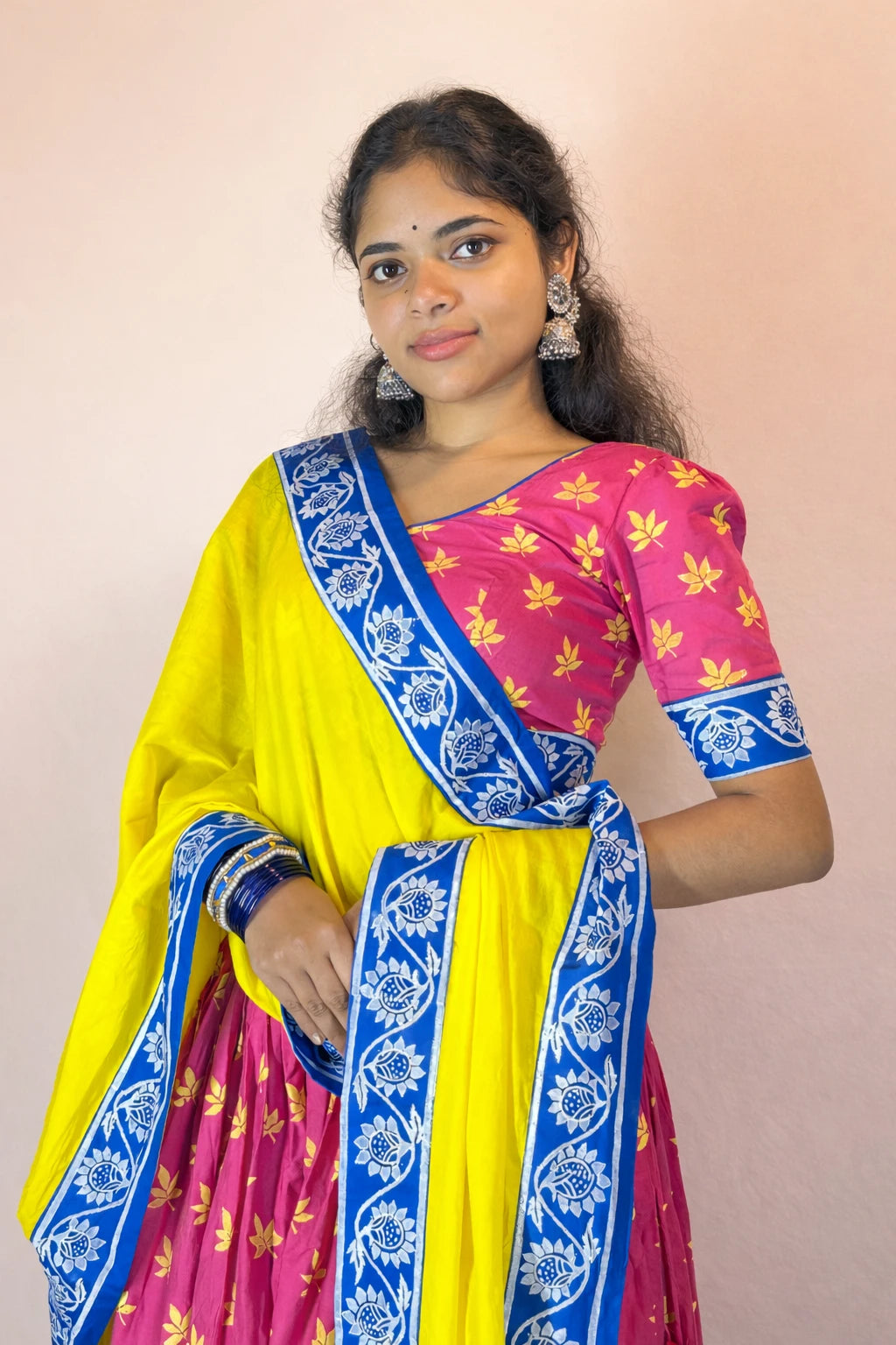 Close-up view of Rasika Rangini Gopi dress showing hand block printed pink blouse and blue floral border detailing