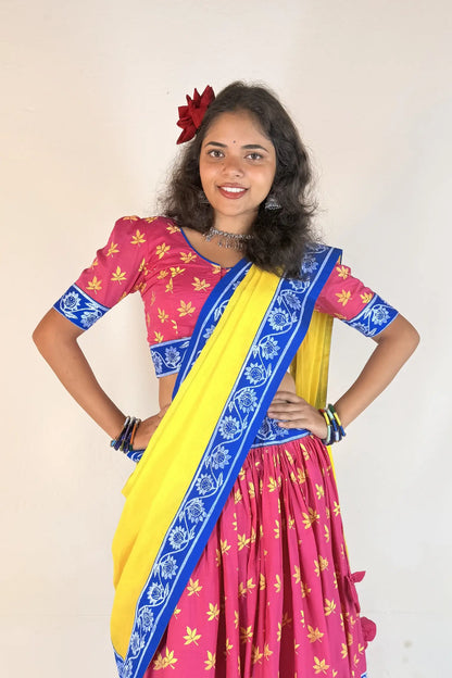 Woman wearing a colorful Gopi Dress with a pink blouse and yellow skirt on a plain background