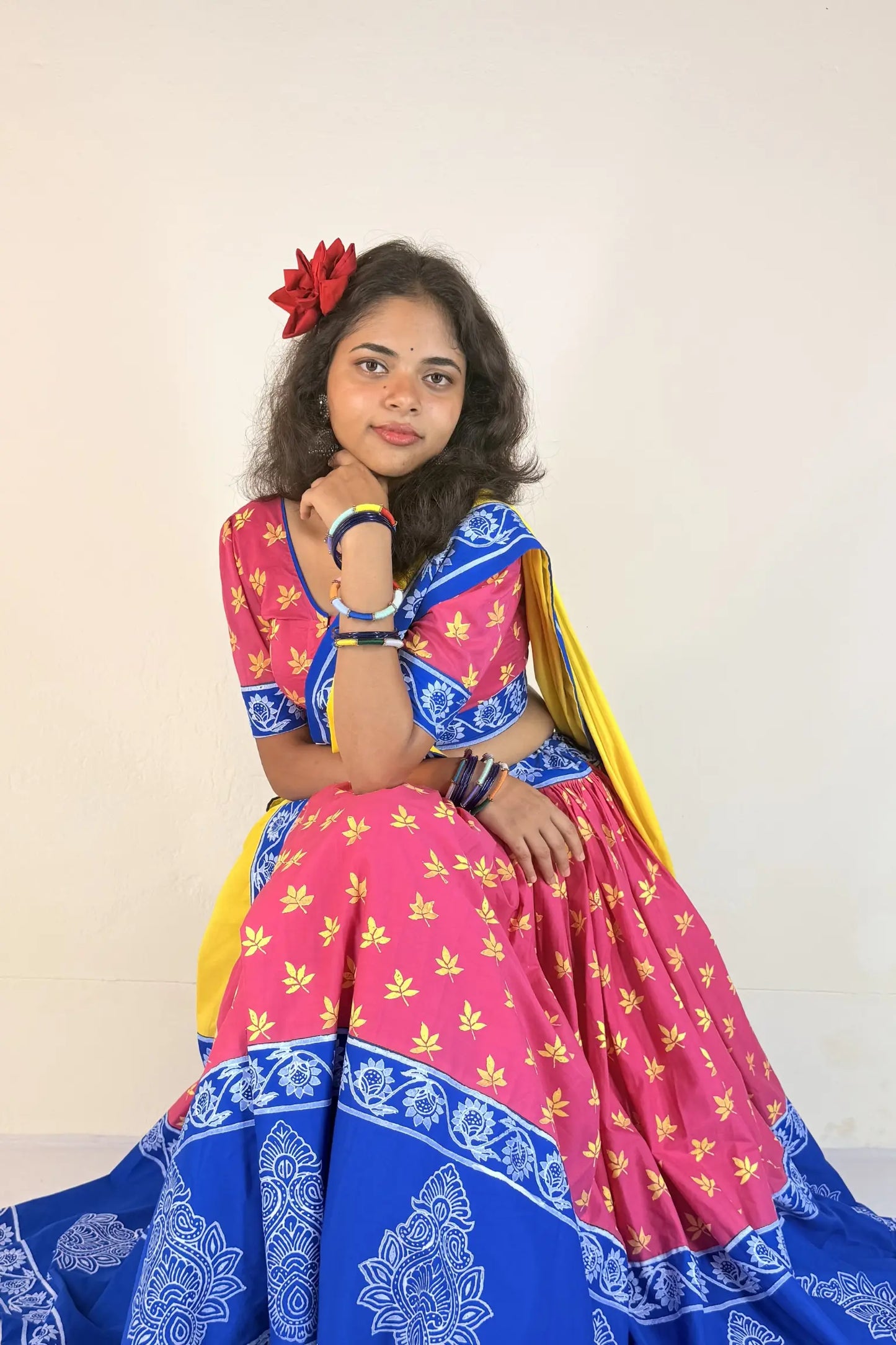 Woman wearing a white and blue traditional outfit with a plain background