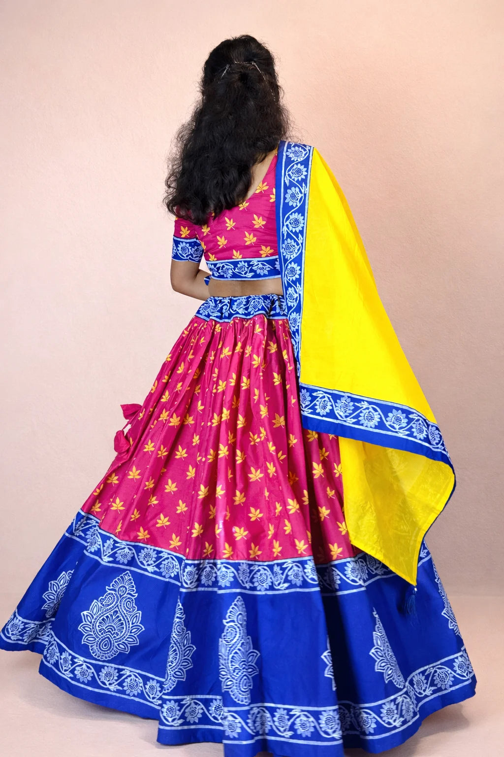 Back view of Rasika Rangini Gopi dress showcasing hand block printed pink skirt and flowing yellow dupatta