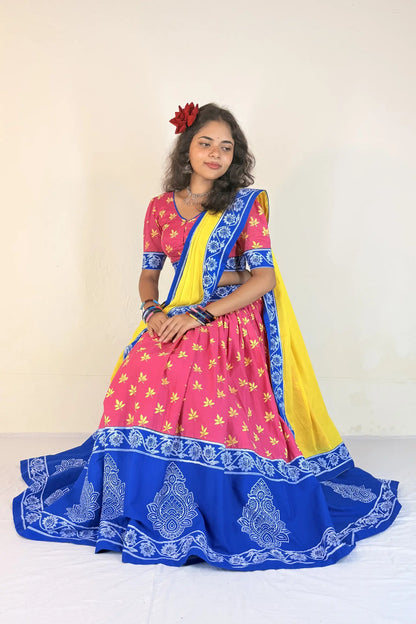 Woman wearing a white Gopi Dress with blue patterns against a beige background