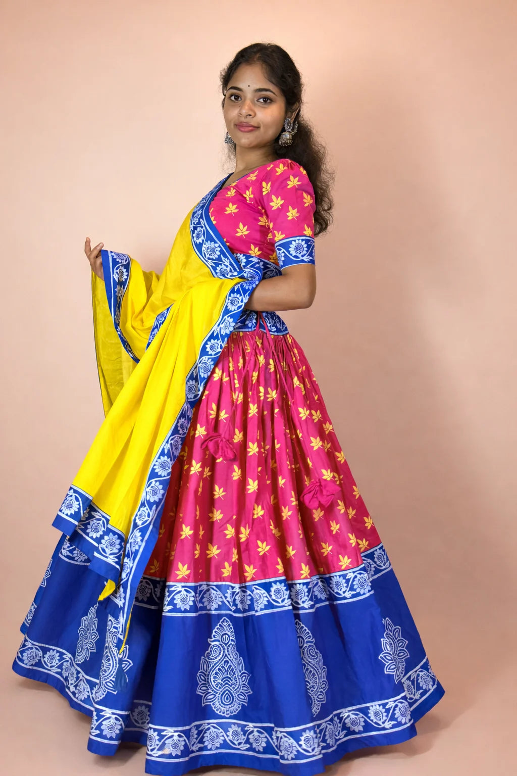 Side view of hand block printed Rasika Rangini Gopi dress in yellow, pink and blue with traditional flared silhouette