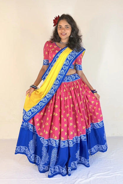 Woman wearing a colorful traditional outfit with a pink and blue Gopi Dress and yellow blouse.