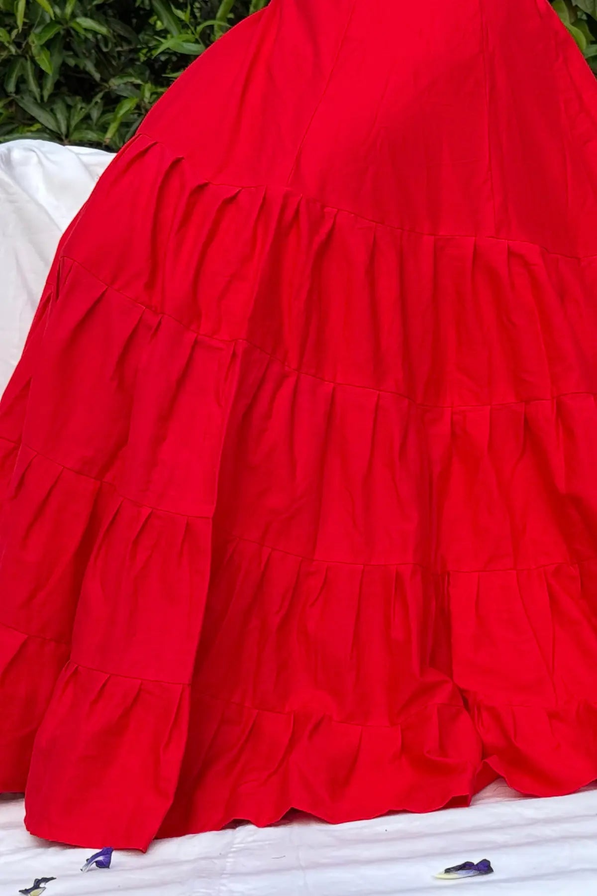 Close-up view of red cotton petticoat underskirt fabric showing layered pleats and stitching details