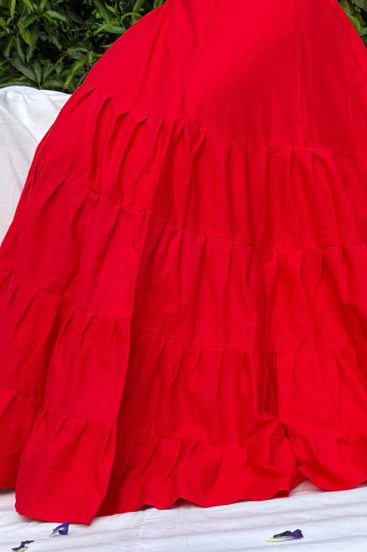 Close-up view of red cotton petticoat underskirt fabric showing layered pleats and stitching details