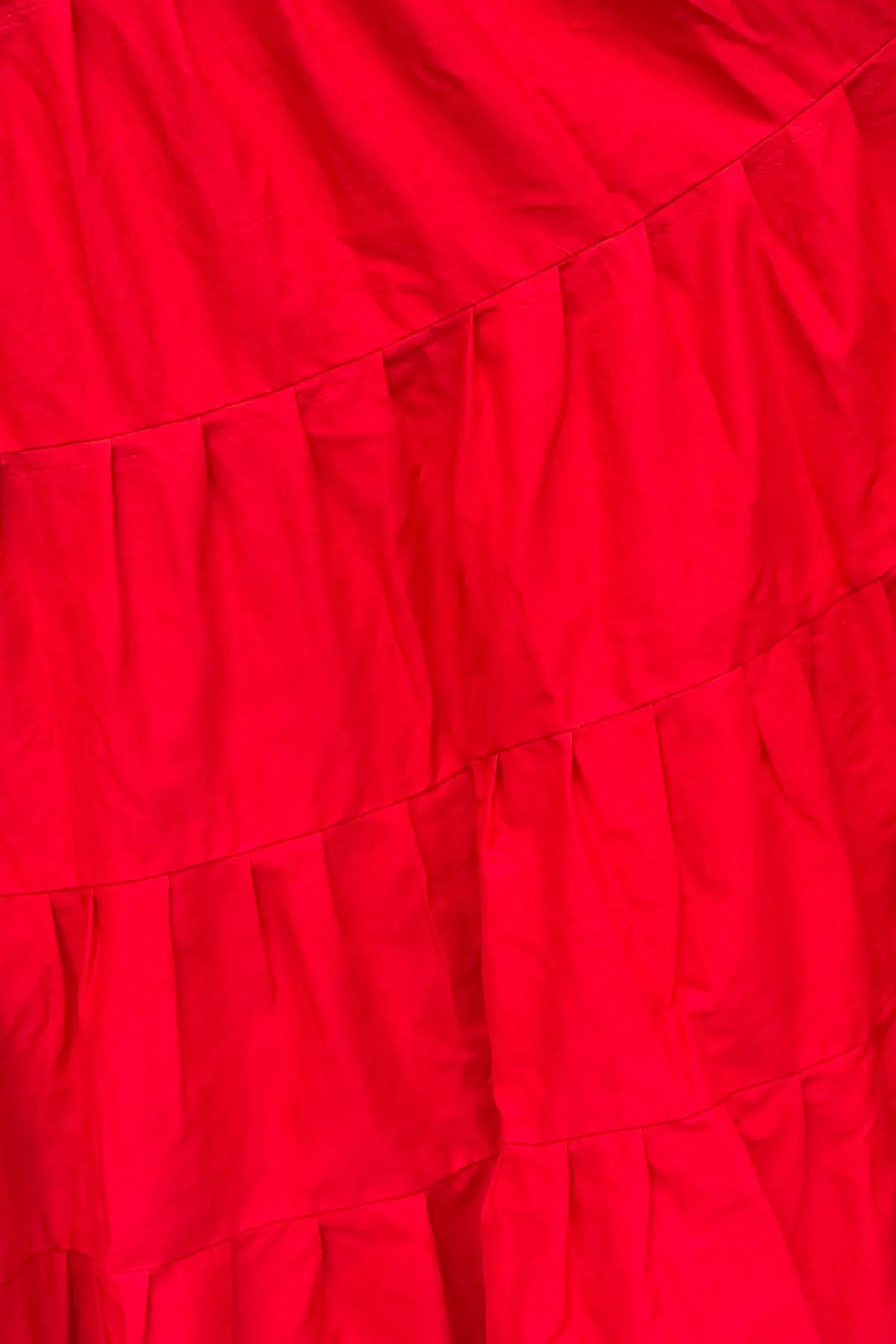 Detailed back view of red cotton petticoat underskirt showing multiple gathered layers and smooth fall
