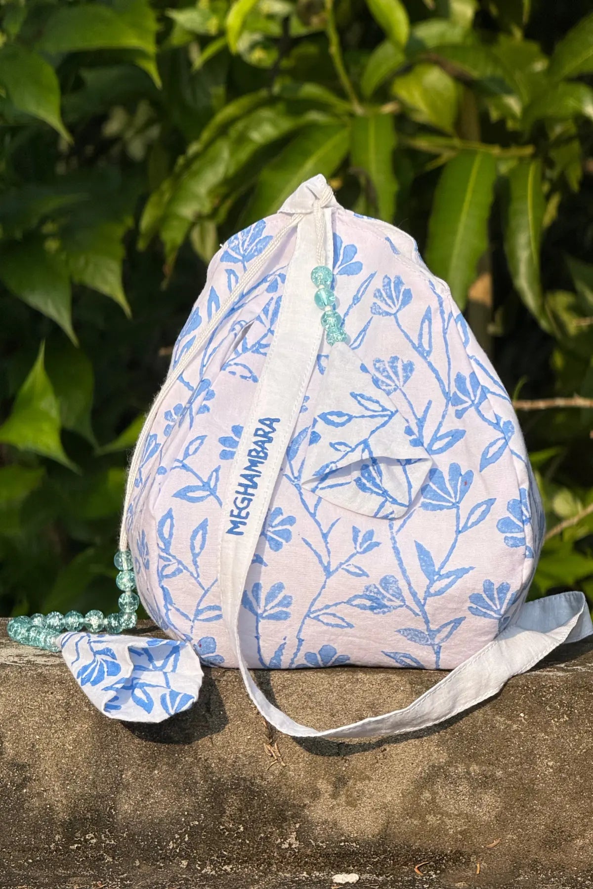White and blue hand block printed cotton japa mala bag with drawstring closure and decorative japa mala beads, handcrafted by Meghambara